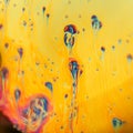 Yellow macro photograph of soap bubble with blue and red shapes forming Royalty Free Stock Photo