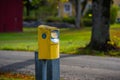 A yellow mail box beside a road