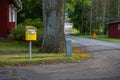 A yellow mail box beside a road