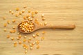 Yellow maize corn kernels ready for making popcorn, on bamboo cutting board and in wooden spoon Royalty Free Stock Photo