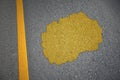 yellow map of macedonia country on asphalt road near yellow line