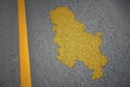 yellow map of serbia country on asphalt road near yellow line