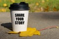 On a yellow maple leaf there is a cup of coffee on which is written - share your story Royalty Free Stock Photo