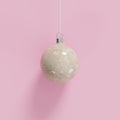 Yellow marble Christmas ball ornament on pink background