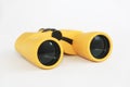 Yellow marine optical plastic binoculars on a white background