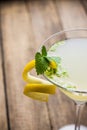 Yellow martini cocktail with lemon and mint