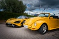 Yellow McLaren 765LT and VW Beetle Convertible Under Cloudy Skies Royalty Free Stock Photo