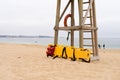 Yellow medical backboard leaning on wooden lifeguard tower Royalty Free Stock Photo