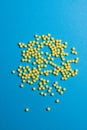 Yellow medical pills on blue background with copy space for text. Alternative homeopathy medicine, healthcare and Royalty Free Stock Photo