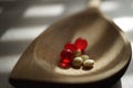 Yellow medical pills and red vitamins a wooden spoon. Drug treatment Royalty Free Stock Photo