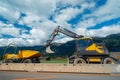 Yellow medium wheeled excavator with mini dumper Royalty Free Stock Photo