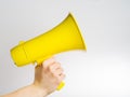 Yellow megaphone in a man`s hand on a white background. There is free space to insert. Loudspeaker, fake news, false news,