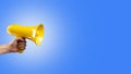 Yellow megaphone on a sky blue background. false information, rumors, fakes, elections, debates, advertising, yellow press. There