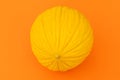 Yellow melon on bright orange background. Flat lay. Creative food concept