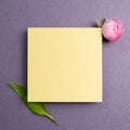 Yellow memo pad with pink flower on purple background Royalty Free Stock Photo