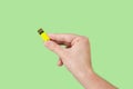 Yellow memory stick on hand with green background Royalty Free Stock Photo