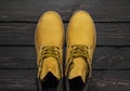 Yellow men`s work boots from natural nubuck leather on dark wooden background top view flat lay with copy space. Trendy casual Royalty Free Stock Photo