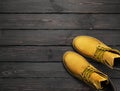 Yellow men`s work boots from natural nubuck leather on dark wooden background top view flat lay with copy space. Trendy casual Royalty Free Stock Photo