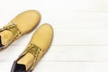 Yellow men`s work boots from natural nubuck leather on wooden white background top view flat lay with copy space. Trendy casual Royalty Free Stock Photo