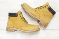 Yellow men`s work boots from natural nubuck leather on wooden white background top view flat lay with copy space. Trendy casual Royalty Free Stock Photo