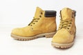 Yellow men`s work boots from natural nubuck leather on wooden white background. Trendy casual shoes, youth style. Concept of Royalty Free Stock Photo