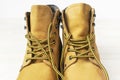 Yellow men`s work boots from natural nubuck leather on wooden white background. Trendy casual shoes, youth style. Concept of Royalty Free Stock Photo