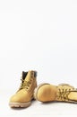 Yellow men`s work boots from natural nubuck leather on wooden white background. Trendy casual shoes, youth style. Concept of Royalty Free Stock Photo