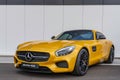 a yellow mercedes sports car parked on the side of a road