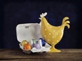 Yellow metal chicken with colourful Easter eggs in egg box. Royalty Free Stock Photo