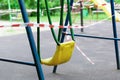 Yellow metal children\'s swing on a sports playground in the park wrapped with red barrier tape