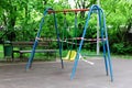 Yellow metal children\'s swing on a sports playground in the park wrapped with red barrier tape