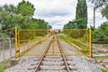 Yellow metal fence across the railroad