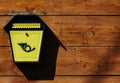 Yellow metal mailbox on a wooden wall