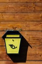 Yellow metal mailbox on a wooden wall