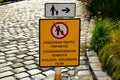 yellow metal plate street traffic sign with Pedestrian Traffic Prohibited warning. cobblestone road