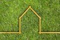 Yellow meter ruler folded as house on green grass