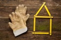 Yellow meter tool with pair of working gloves on vintage wooden background. Royalty Free Stock Photo