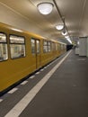 Yellow metro train leaving a station in Berlin Royalty Free Stock Photo