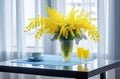 Yellow mimosa flowers stand in a glass vase on the table. Holiday concept, postcards
