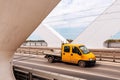 Yellow mini truck speeding over modern bridge, used in intra-city low tonnage cargo delivery Royalty Free Stock Photo