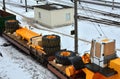 Yellow mining truck disassembled into parts, cab, body, electric motor, drive, wheels, loaded onto a cargo railway platform.