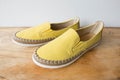 Yellow moccasin shoes on wooden table