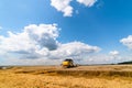 A yellow modern combine harvester working in a wheat field Royalty Free Stock Photo