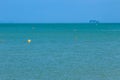Yellow Mooring balls are floating in the blue sea with island and blue sky background. Royalty Free Stock Photo