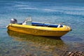 Yellow motor boat moored to the sea shore