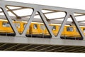 Yellow moving train on an iron bridge with blue sky, isolated on