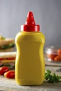 Yellow mustard squeeze bottle container with no label. Breakfast sandwich on background. Food product Royalty Free Stock Photo