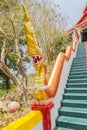 Yellow Naka (giant snake) statue on top of main stair leading to the replica of Phra That In-Kwaen (Hanging Golden