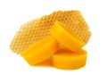 Yellow natural bee wax with a piece of honey cell on a white background.