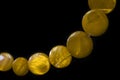 Yellow necklace made of round flat beads on a dark background Royalty Free Stock Photo